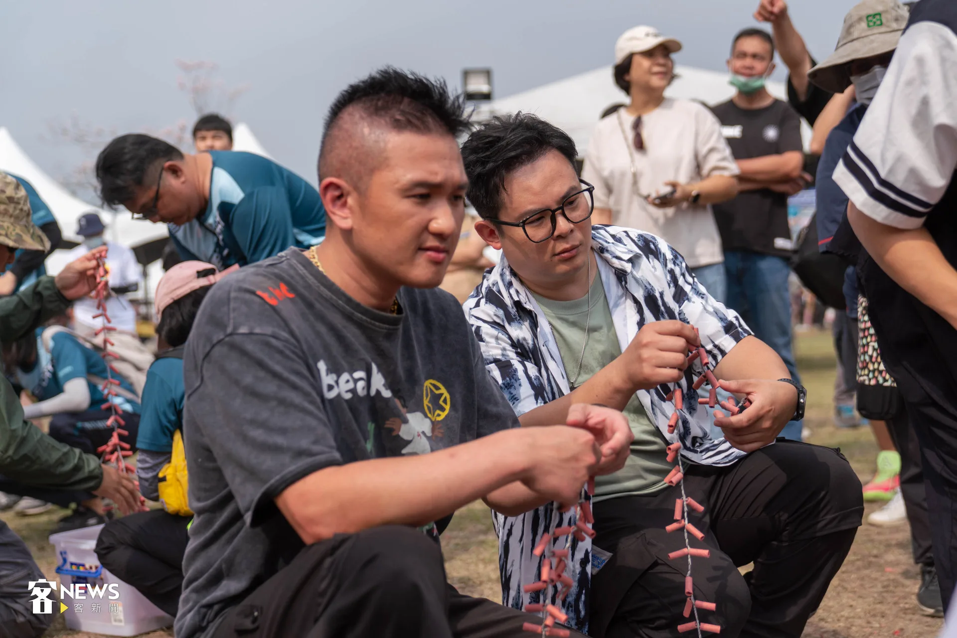 客家電視台《啊喔！最Kiang駐村小隊》來賓iColor主唱邱廉欽（右）、吉他手戴陽（左）也來體驗尖炮城，親手綁要投擲的鞭炮。范修語攝