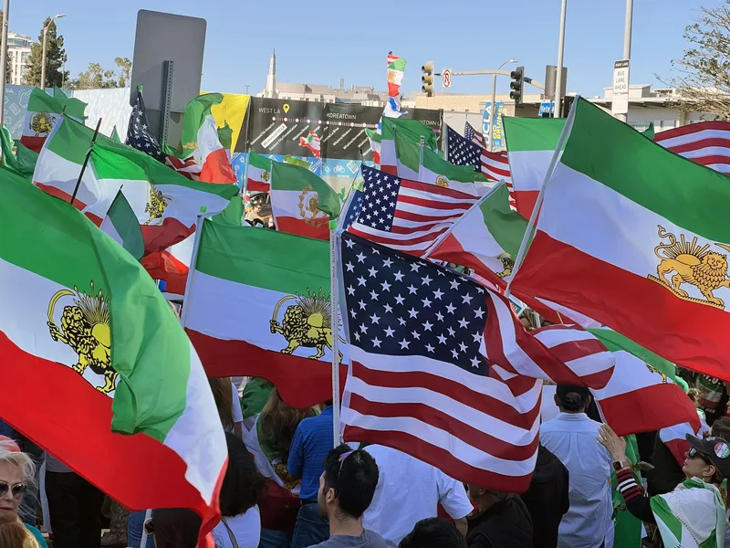 洛杉磯數百名伊朗人在聯邦政府大樓前示威，支持已故伊朗國王之子、王儲芮沙．巴勒維（Reza Pahlavi）回歸，現場一片旗海，都是1979年伊斯蘭革命之前巴勒維王朝的「獅子與太陽」旗幟。中央社，20260308