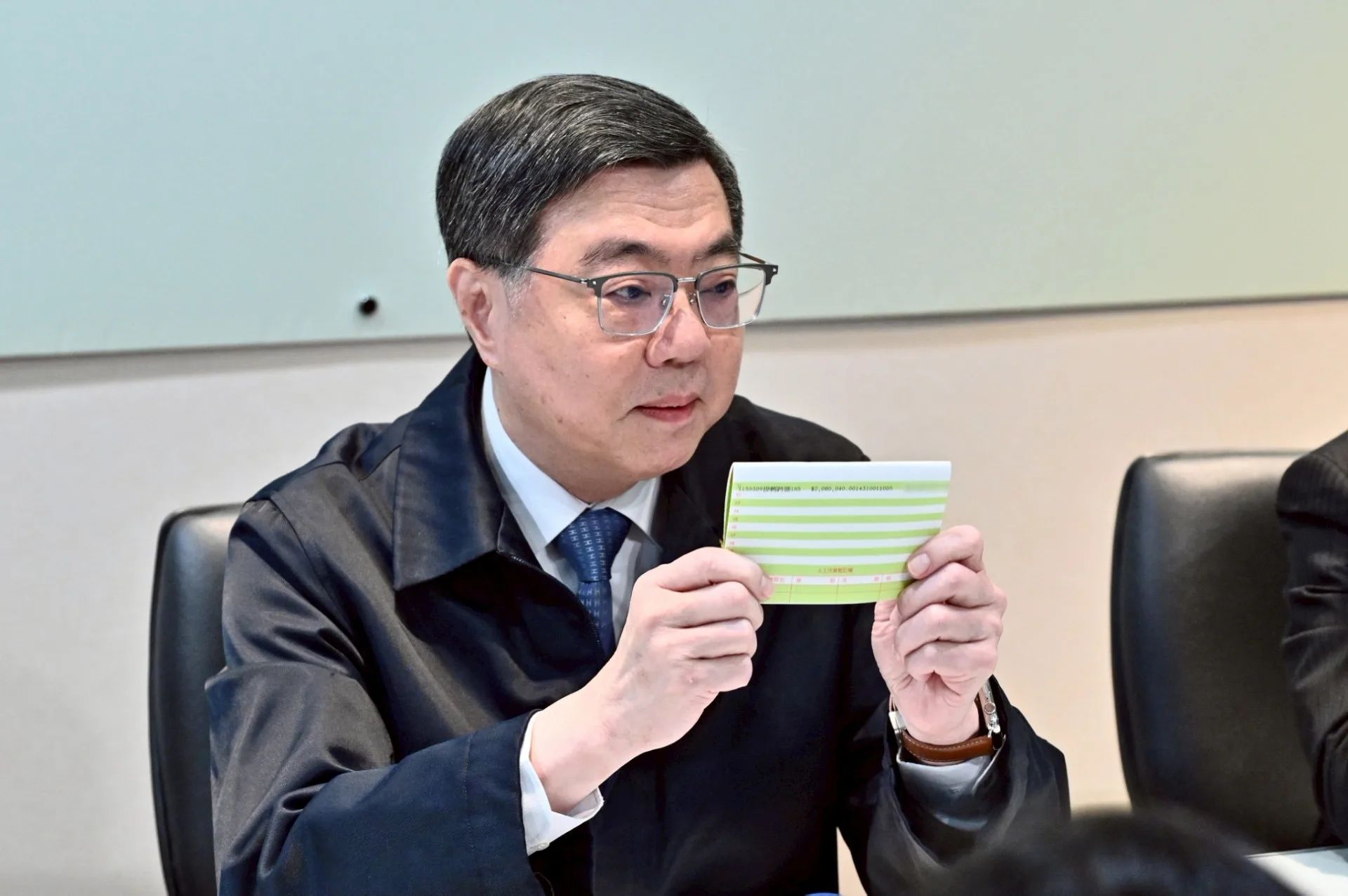 卓榮泰拿出存摺影本佐證自費包機。行政院提供