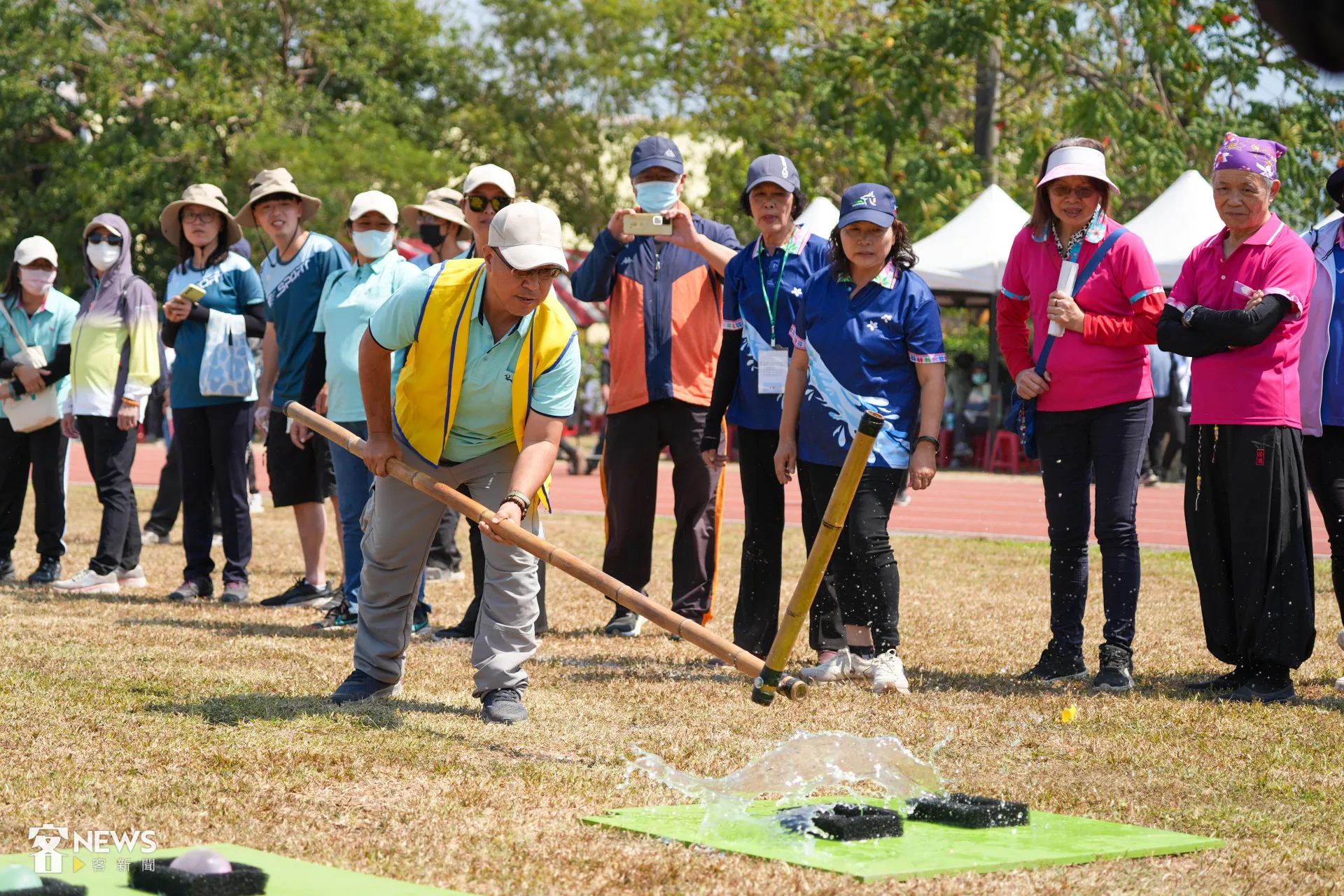 趣味競賽「講諺語、打豆莢」,參賽者說完諺語後必須用長桿打破水球。李台源攝