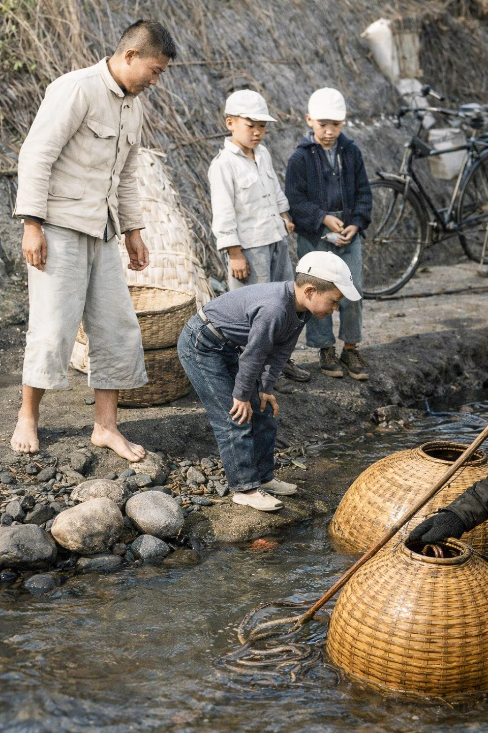 很早之前，許多孩子站在溪畔，看著漁民捕捉鰻魚。那樣的景象，如今只能在老照片裡回憶。陳權欣提供