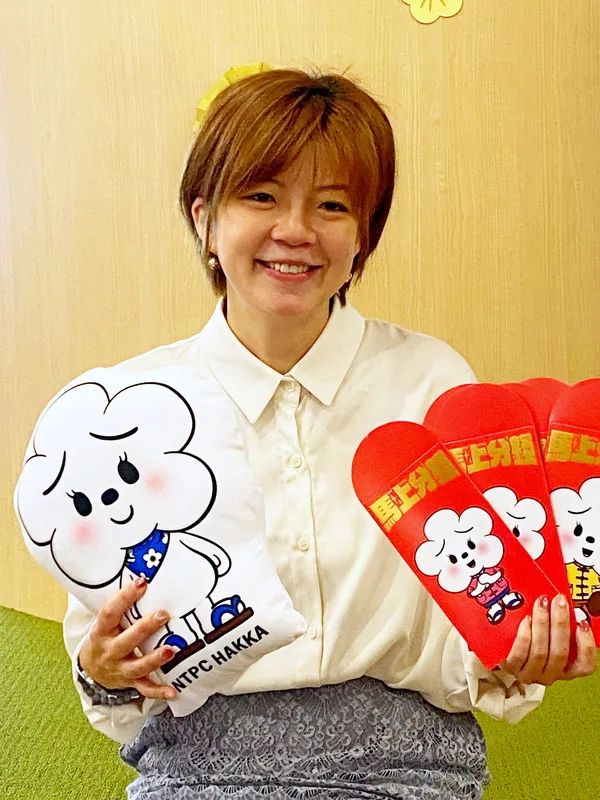 新北市政府客家事務局長劉冠吟（圖）18日介紹客家局自己設計的IP「發桐醬」，是「花朵很漂亮」的客語諧音，八字眉表情的油桐花小精靈，將擔任行銷大使。中央社