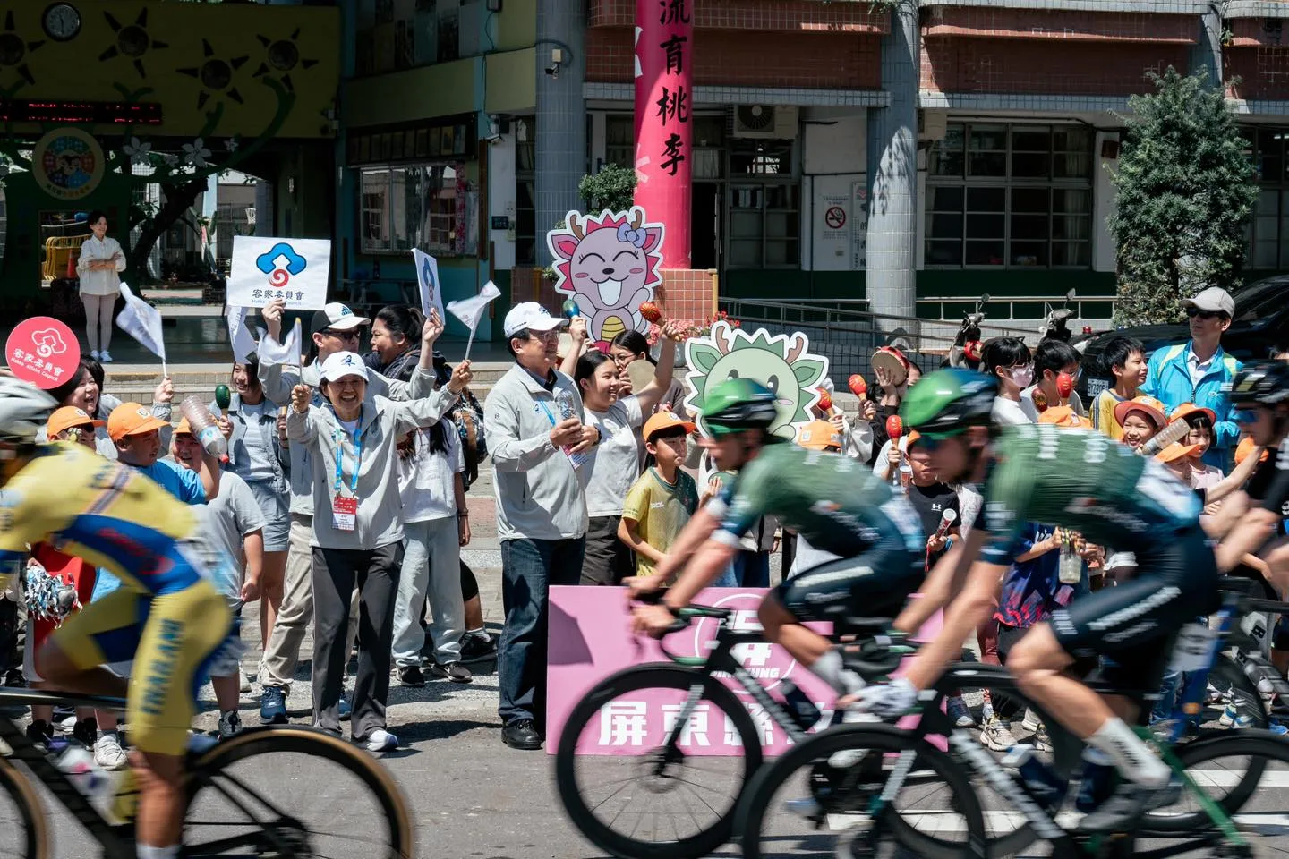 客委會主委古秀妃揮舞旗幟，替各國環台賽選手加油。國際自由車環台公路大賽提供