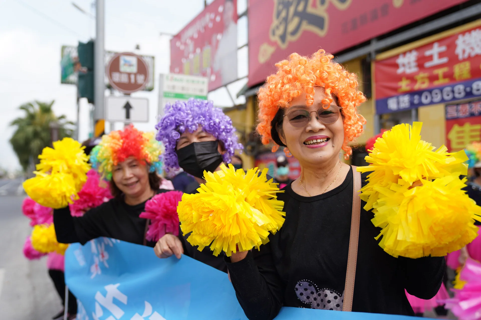 光復鄉婦女會加油團戴爆炸頭，舉彩球歡呼加油。蔡依璇攝