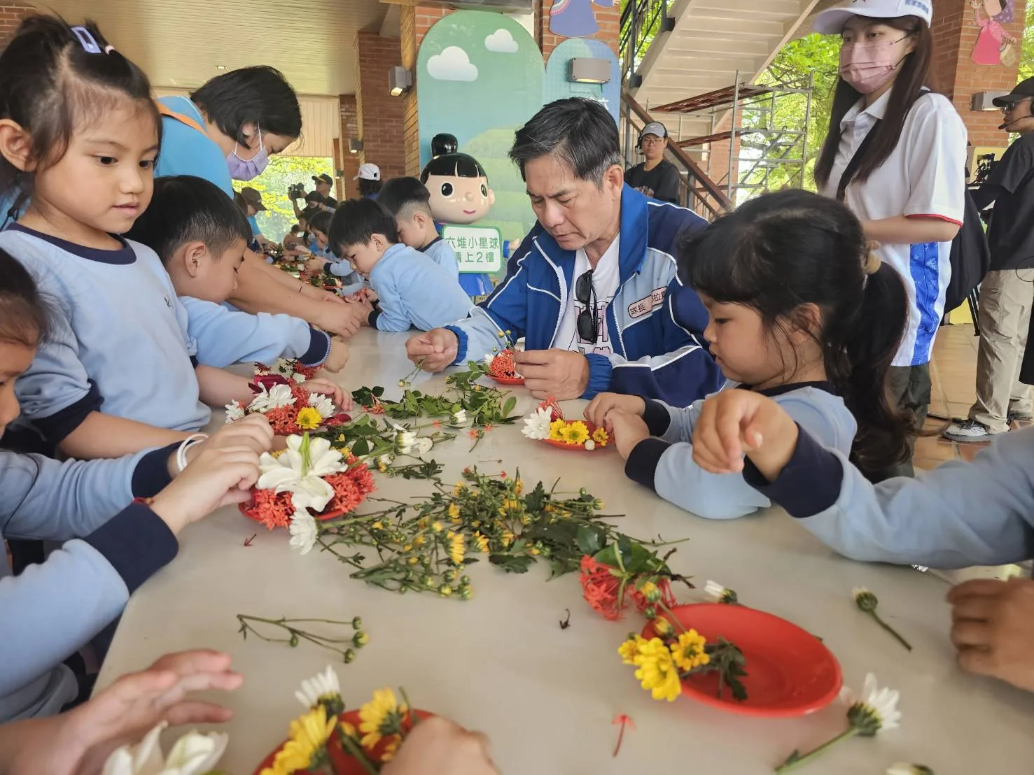 藝人洪都拉斯與學童一起疊盤花。客發中心提供
