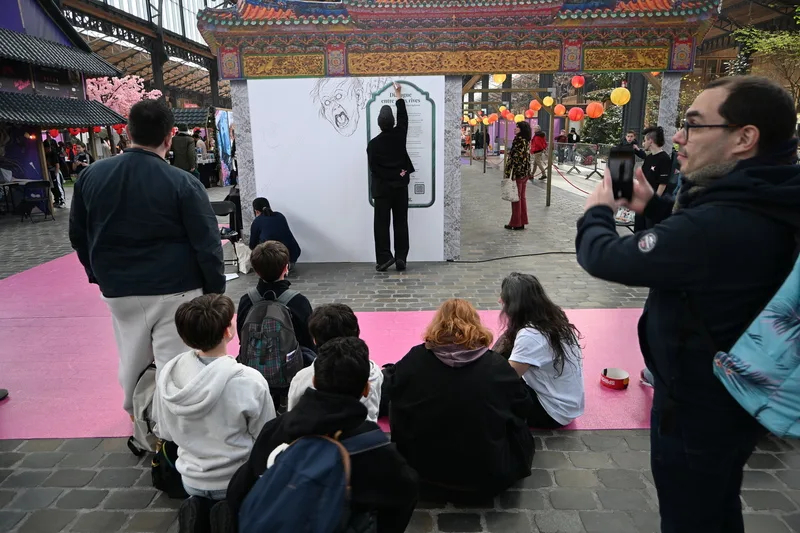 艾莉柚與藥島在布魯塞爾書展會場合作創作漫畫,吸引許多民眾圍觀、拍攝。中央社