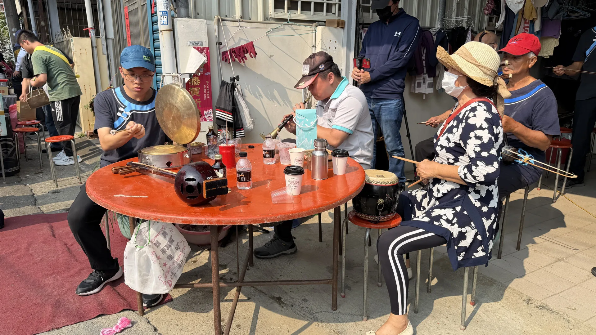 吳梓銜(左)、潘俊名(中)、蘇櫻菊(右)三人在温福仁告別式上以客家八音作場為老師送行。李慧宜攝