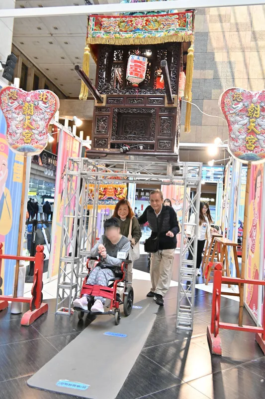 今年唐氏症特展邀請北港朝天宮媽祖駐轎，現場規劃無障礙空間，將鑾轎架高至約1.5公尺，讓輪椅使用者也能參與鑽轎底。中央社
