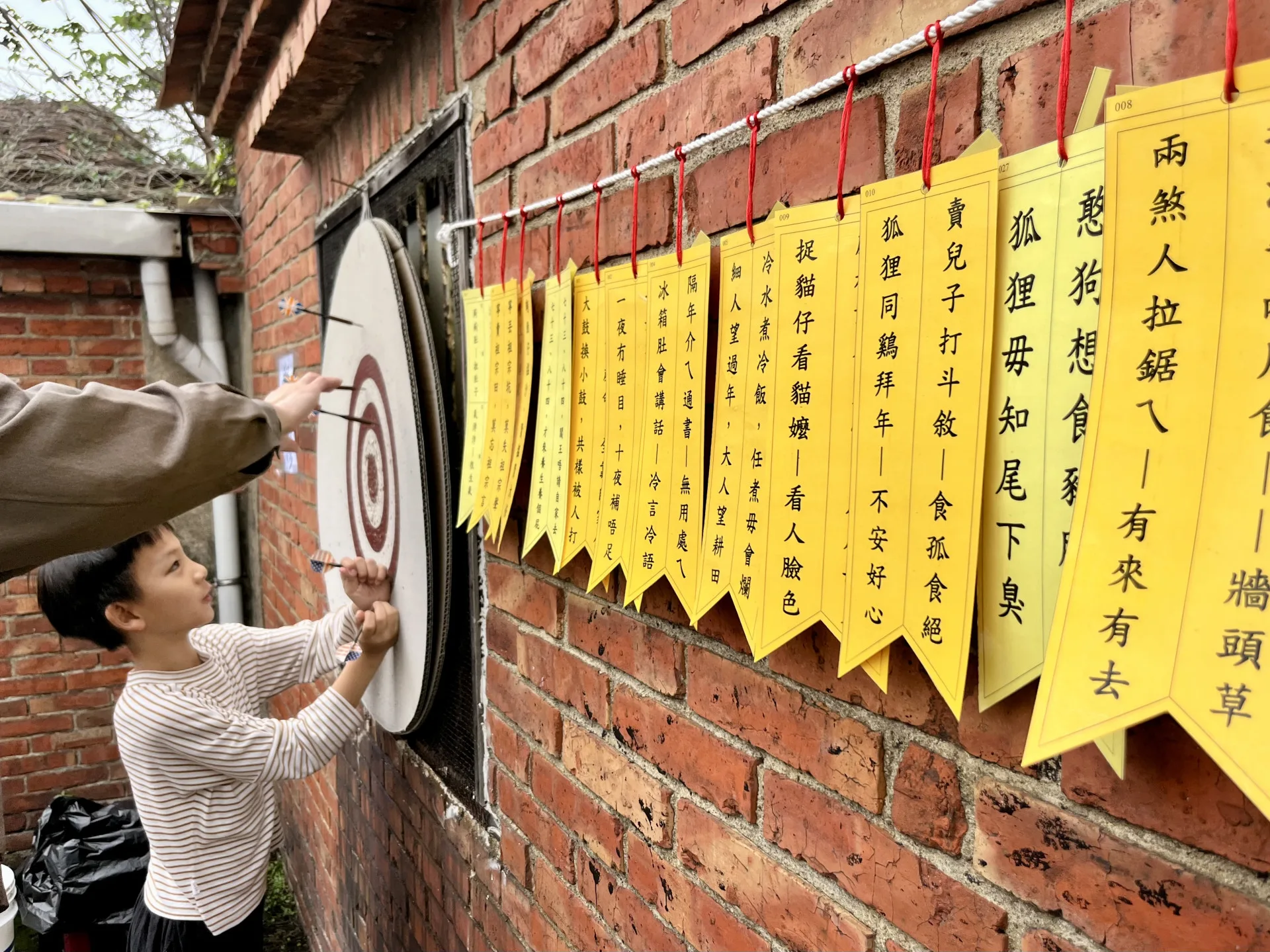 老屋紅磚牆掛滿客家諺語，讓新生代在遊戲與挑戰中，拾起祖先的語言。徐彩雲攝