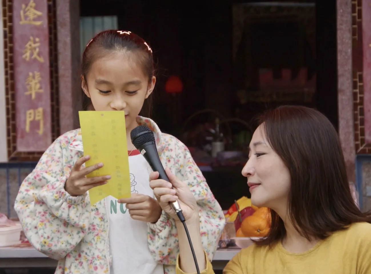 麥克風傳遞出稚嫩的客語，可以找阿公、阿婆當「救火隊」，用有趣的互動守護母語 。徐彩雲攝