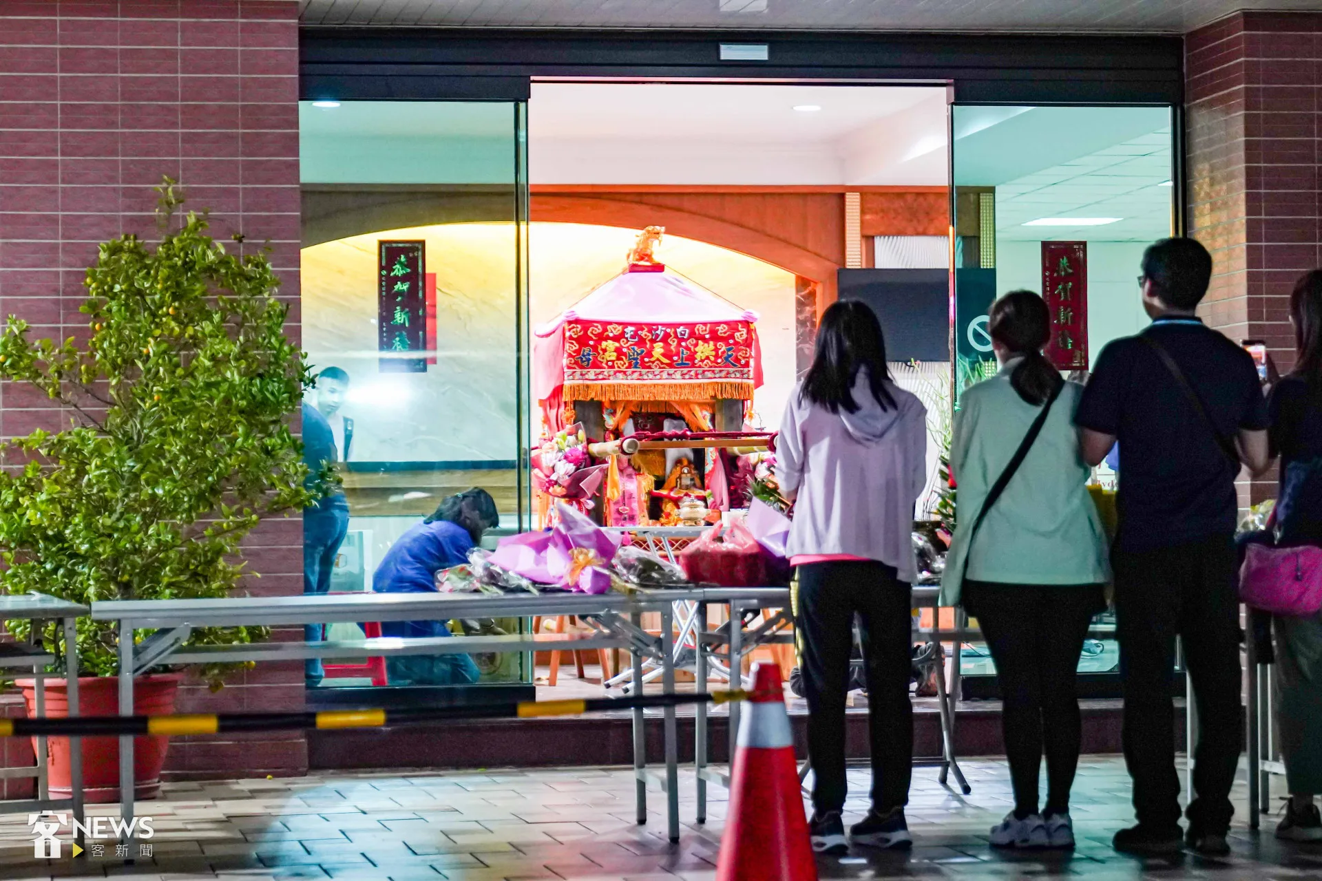 白沙屯媽祖晚間駐駕笠毅公司，信眾排隊在媽祖鑾轎前祈福。朱愷元攝