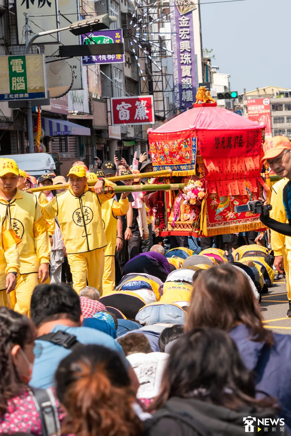 媽祖鑾轎行經時，民眾把握機會鑽轎底祈福。朱愷元攝