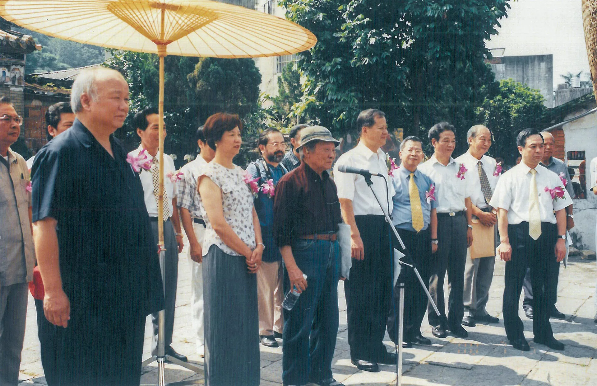 鍾肇政(致賀發言者)參加北埔膨風節的開幕典禮,並帶來祝賀,旁邊站立者為立法委員與縣長等,可見當時林光華(前排左一)縣長對鍾老很是敬重。2000,北埔,楊國鑫攝