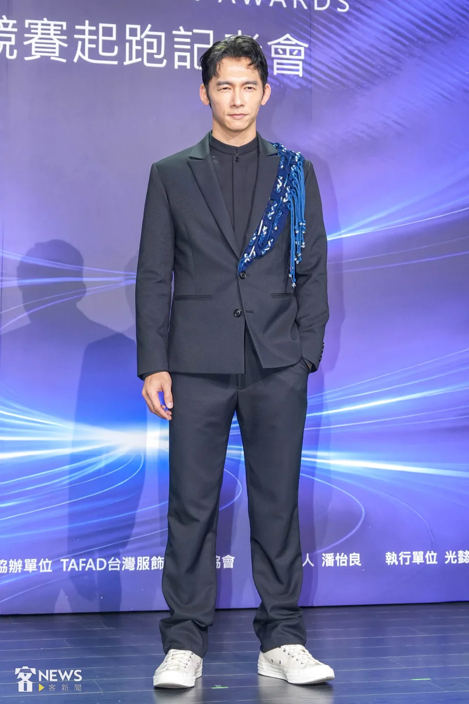 温昇豪身穿俐落剪裁深色西裝，外套左半邊透過藍染織布以及編織線條裝飾，打破既有客家花布印象。李台源攝