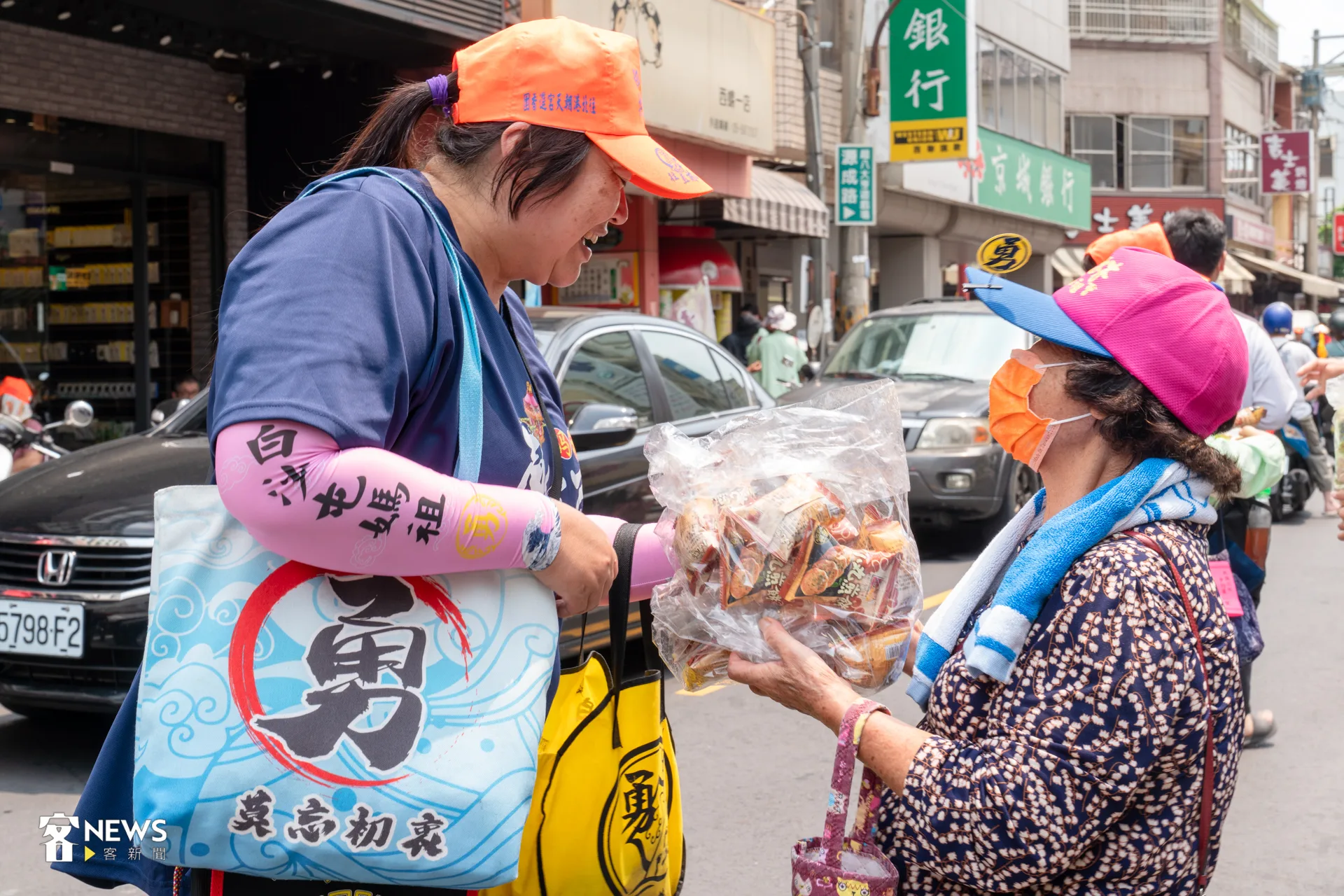 77歲來自雲林土庫的阿媽頂著烈日發送小餅乾給沿途信眾。洪藝晅攝