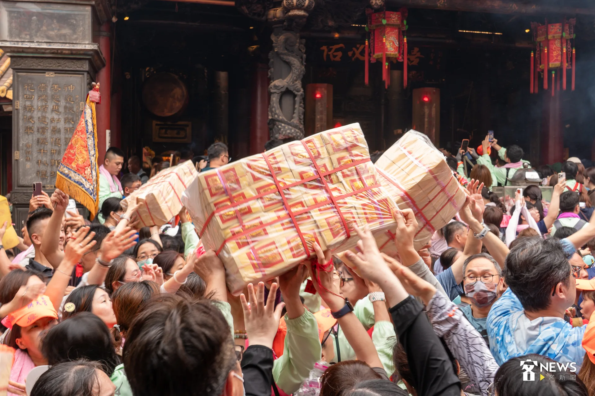 位於廟內的香燈腳透過接力方式，將金紙傳至金爐。洪藝晅攝