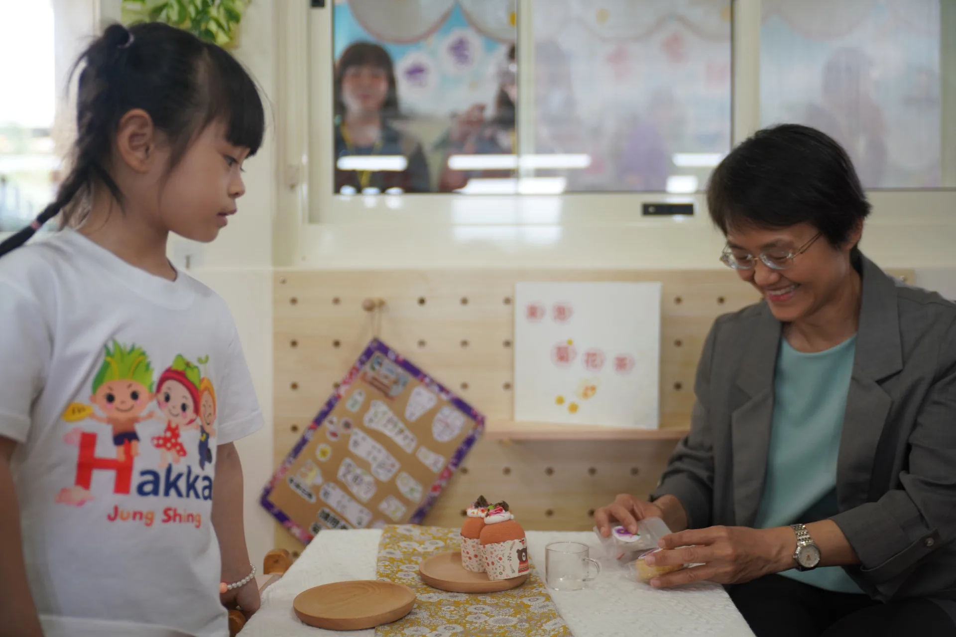 苗栗縣銅鑼鄉中興國小幼兒園孩童扮演小老闆，認真說客語推廣菊花茶點。廖文琪攝