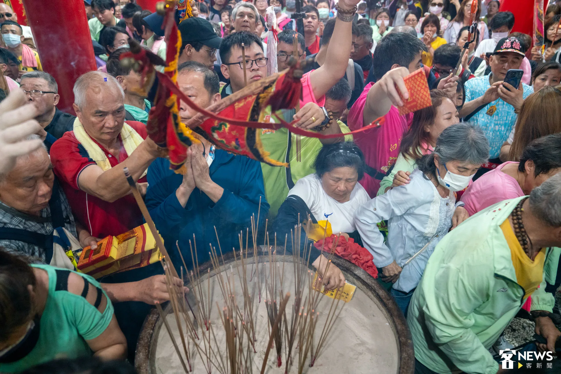 許多香燈腳拿著物品過香爐，祈求媽祖庇佑。范修語攝