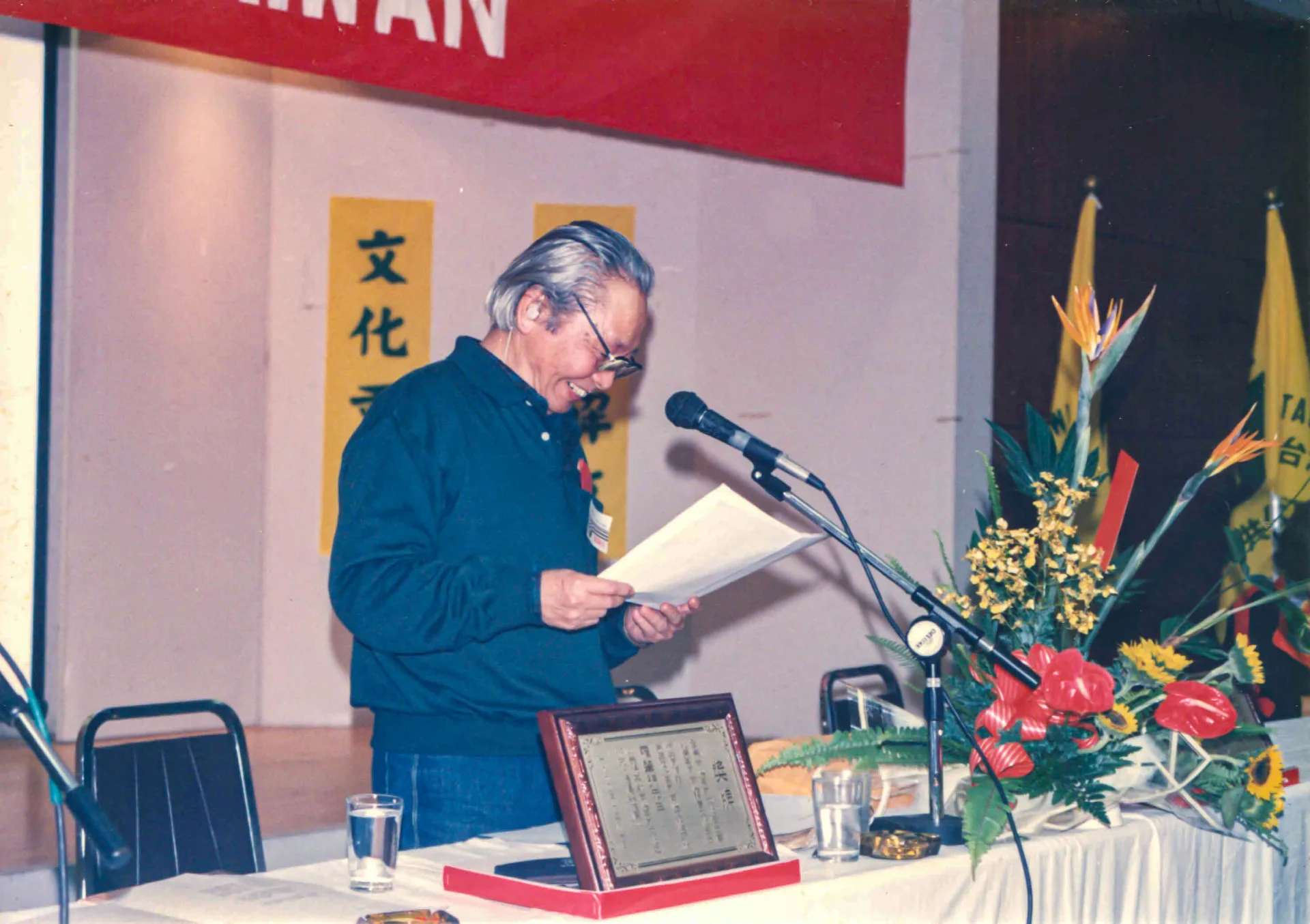 台灣客家公共事務協會1990年在鍾老的帶領下成立，在1994年12月31日與1995年1月1日兩天在中壢藝術館辦理第一屆台灣客家學術研討會。這張照片是台灣客協成立當天拍的，鍾老難得的笑容。1990，台北，楊國鑫攝