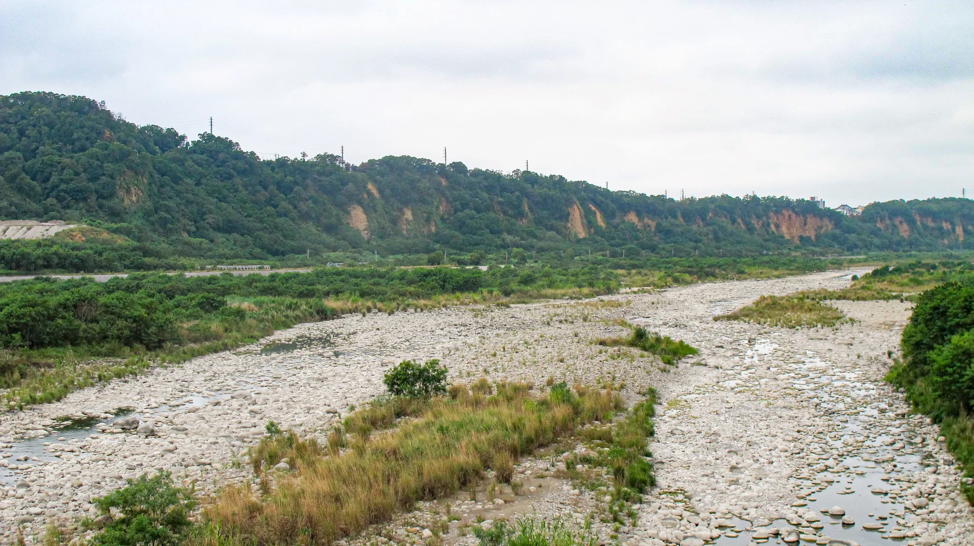 1911年山洪「上夜水打人字礐，下夜水打七十份」，後龍溪河道始往石圍墻庄西側改道，之前後龍溪主流是流經石圍墻庄東側。何來美攝