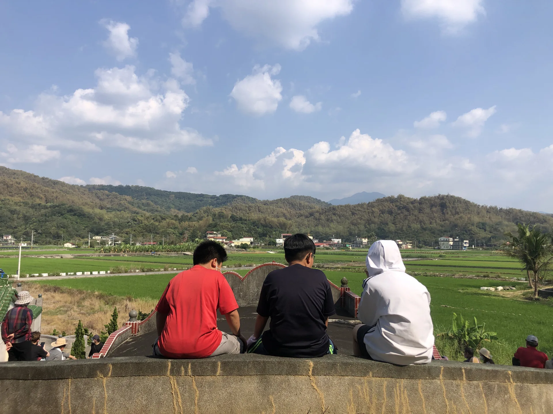 年輕人在祖先墳頭上眺望遠方的家，客家的自我認同在生活中代代相傳。李慧宜攝